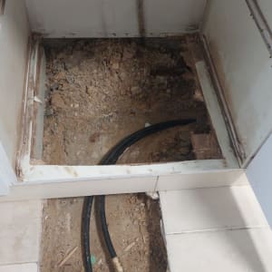 צינורות שחורים מונחים בתעלה באדמה חשופה