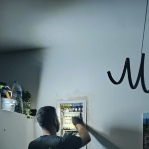 חשמלאי עובד על לוח חשמל עם כלים