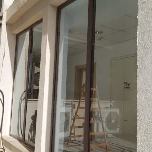 סולם עץ ליד חלון זכוכית לניקוי