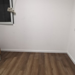 חדר ריק עם רצפת עץ וקיר לבן