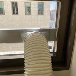 צינור פלסטיק מחובר למסגרת אלומיניום בחלון