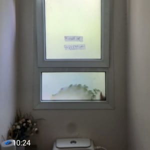 חלון עם זכוכית חלבית בחדר שירותים קטן