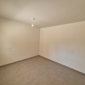 חדר ריק עם קירות בהירים ונורה תלויה