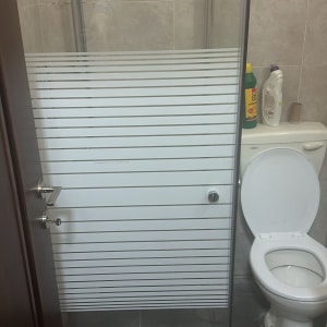 מקלחת עם דלת זכוכית ומקלחת יד