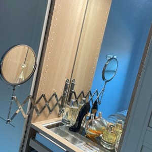 מראה עגולה ומדף עם בקבוקי זכוכית