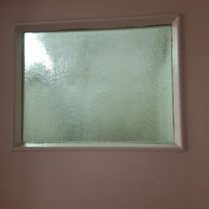 חלון זכוכית מט עם מסגרת לבנה