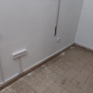 שקעי חשמל על קיר לבן עם חוטים גלויים