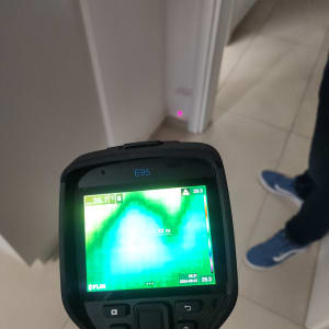 מד חום תרמי מציג נתוני טמפרטורה על קיר