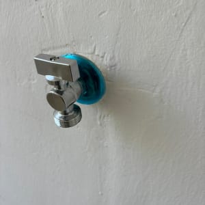 ברז מים מתכת על קיר לבן