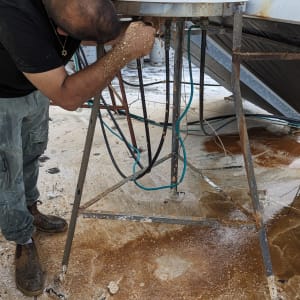 אדם מתקן דוד שמש עם צינורות חשופים