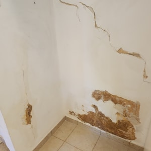 קיר עם סדקים ונזקי רטיבות, מתאים לשיפוץ