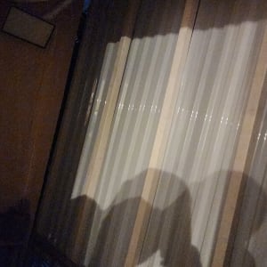 צללים על קיר עץ עם צינור מגולגל