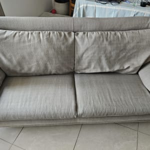 ספה אפורה עם כריות על רצפת אריחים