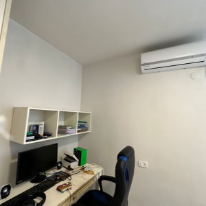 חדר עבודה עם שולחן מחשב וכיסא משרדי