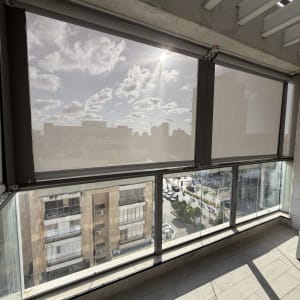 מרפסת עם סוככים שקופים ונוף עירוני