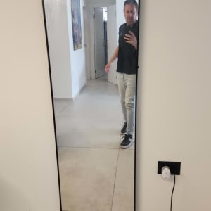 מראה תלויה על קיר עם שקע חשמלי