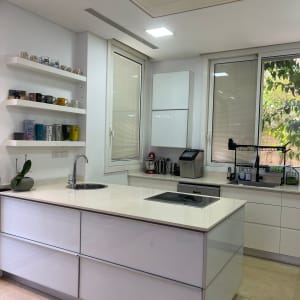 מטבח מודרני עם מדפים, כוסות, כיור וכיריים