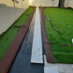 התקנת דשא סינטטי עם יריעות חומות וכלי עבודה