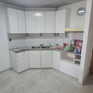 מטבח חדש עם ארונות לבנים ומשטח עבודה אפור