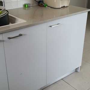 ארונות מטבח עם ידיות מתכת על משטח עבודה