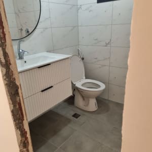 חדר אמבטיה עם אריחים חדשים, כיור ואסלה