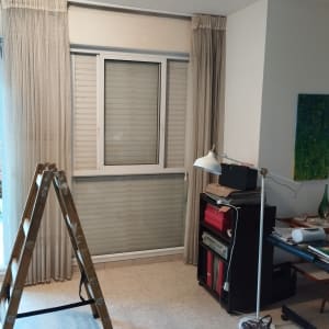 חלון עם תריסים סגורים ומסגרת לבנה