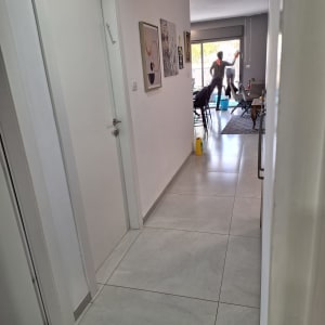 אדם מנקה חלון עם מגב ודלי