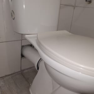 אסלה עם חיבורי צנרת ומיכל הדחה