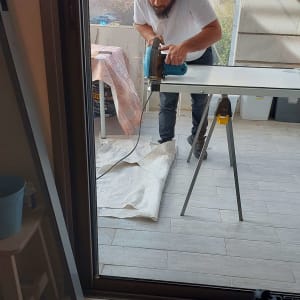 אדם חותך חומר עם מסור חשמלי על שולחן עבודה