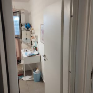 דלת לבנה פתוחה למחצה עם ידית כסופה