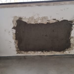 קיר עם טיח מתוקן וצינורות חשופים