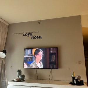 טלוויזיה תלויה על קיר עם כבלים חשופים