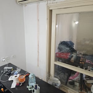נזילה בקיר מתחת למזגן עם סימני רטיבות