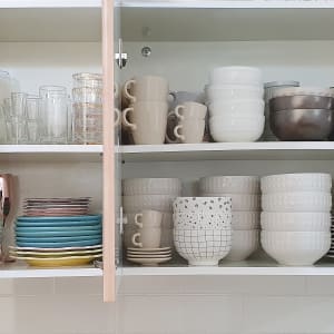 ארון מטבח עם כוסות, צלחות וקערות מסודרים