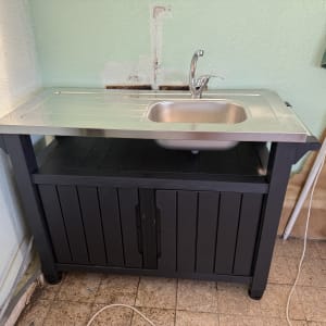 כיור נירוסטה עם ברז על ארון שחור