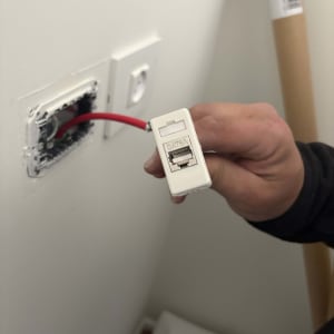 טכנאי מחזיק כבל רשת אדום עם מחבר CAT6A