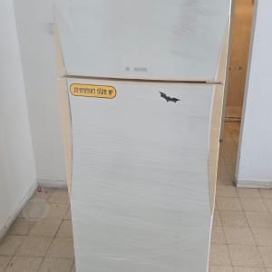 מקרר עטוף בניילון עומד בחדר ריק