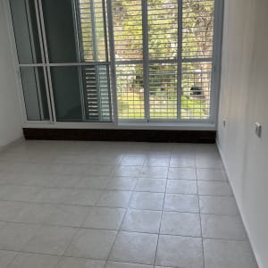 רצפה נקייה עם חלון גדול ותריסים