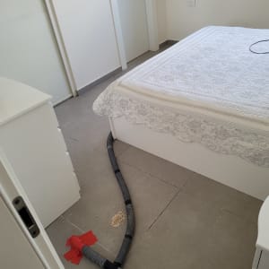 צינור ייבוש על רצפת חדר שינה ליד מיטה