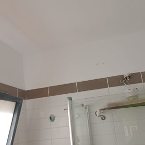 חוטי חשמל חשופים בתקרה ליד מדף זכוכית