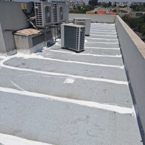 גג עם קווים לבנים לאיטום סביב מזגנים