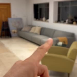 סלון מרוהט בדירה עם יד המצביעה לכיוון הספה