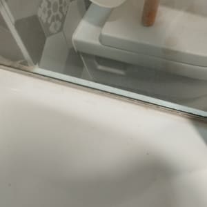 מקלחון עם דלת זכוכית ורצפת אמבטיה