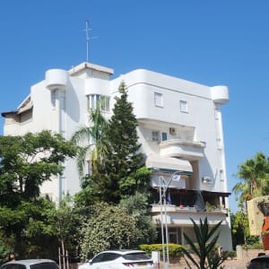 מנוף עבודה ליד בניין לבן עם מרפסות