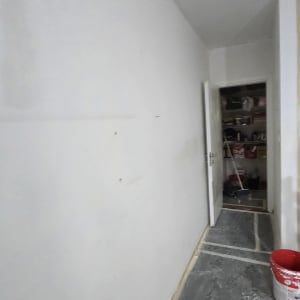 קיר צבוע עם דלי צבע במסדרון