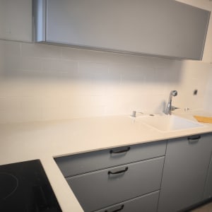 מטבח משופץ עם ארונות אפורים וכיור חדש