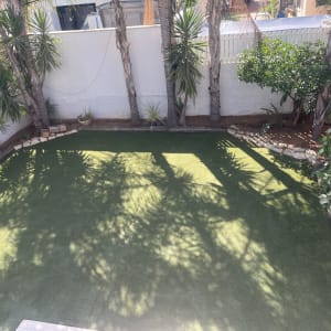 גינה עם דשא סינטטי ועצים מסביב