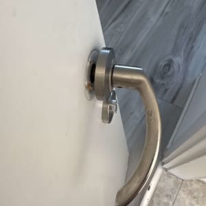 ידית דלת מתכתית על דלת לבנה