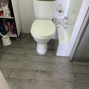 אסלה עם מכסה פתוח וחיבור צינור מים