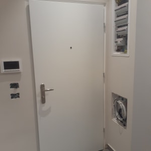 דלת לבנה עם ידית מתכת, לוח חשמל פתוח